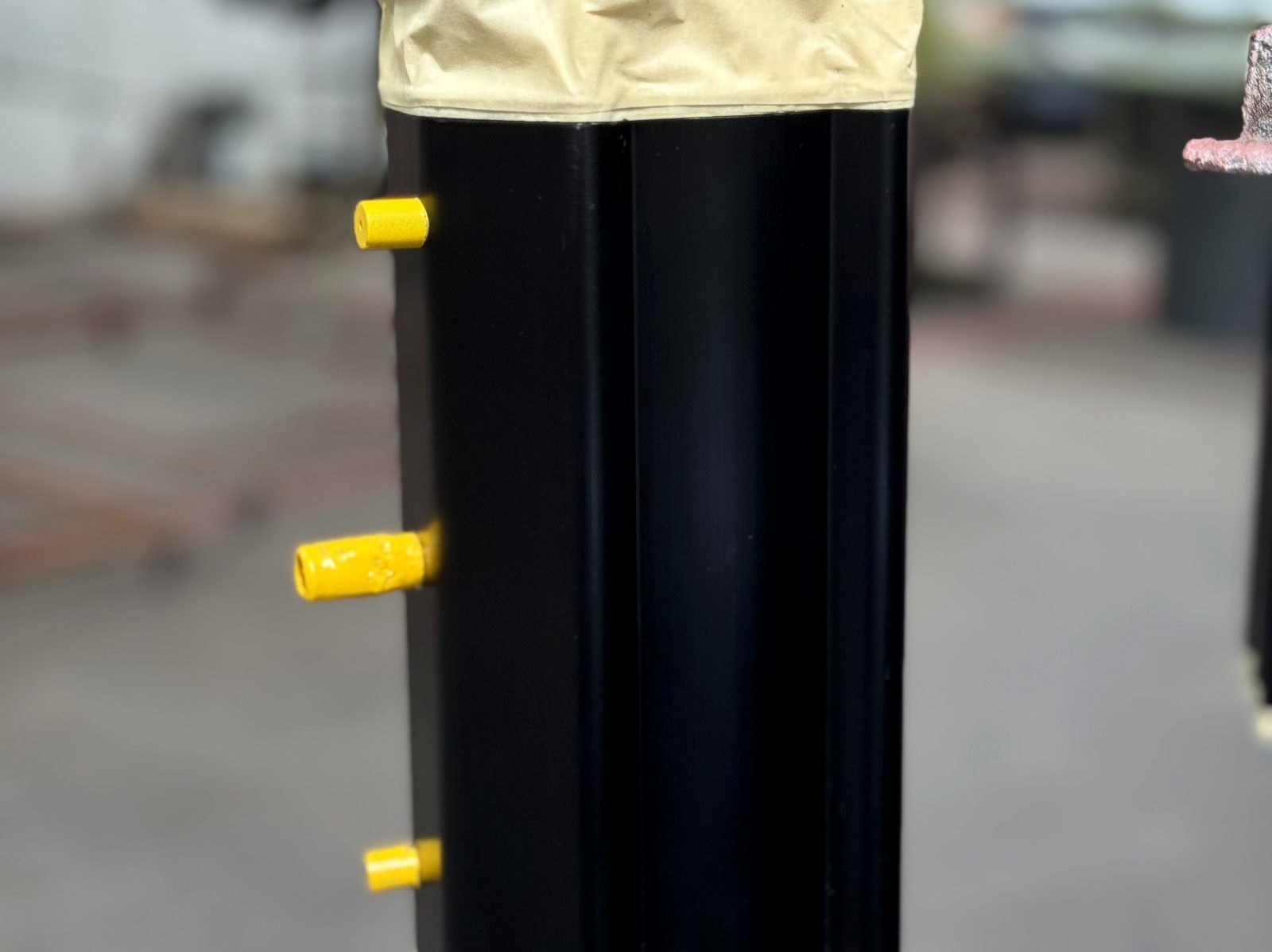 Part masked with tape and plugs before powder coating