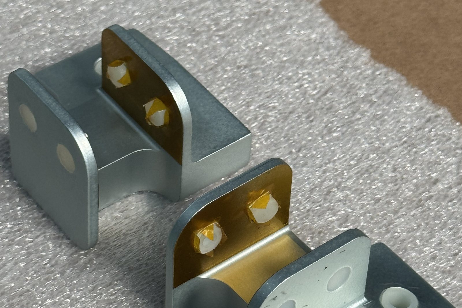 Aluminium brackets with gold chem film on the bonding faces and masked holes