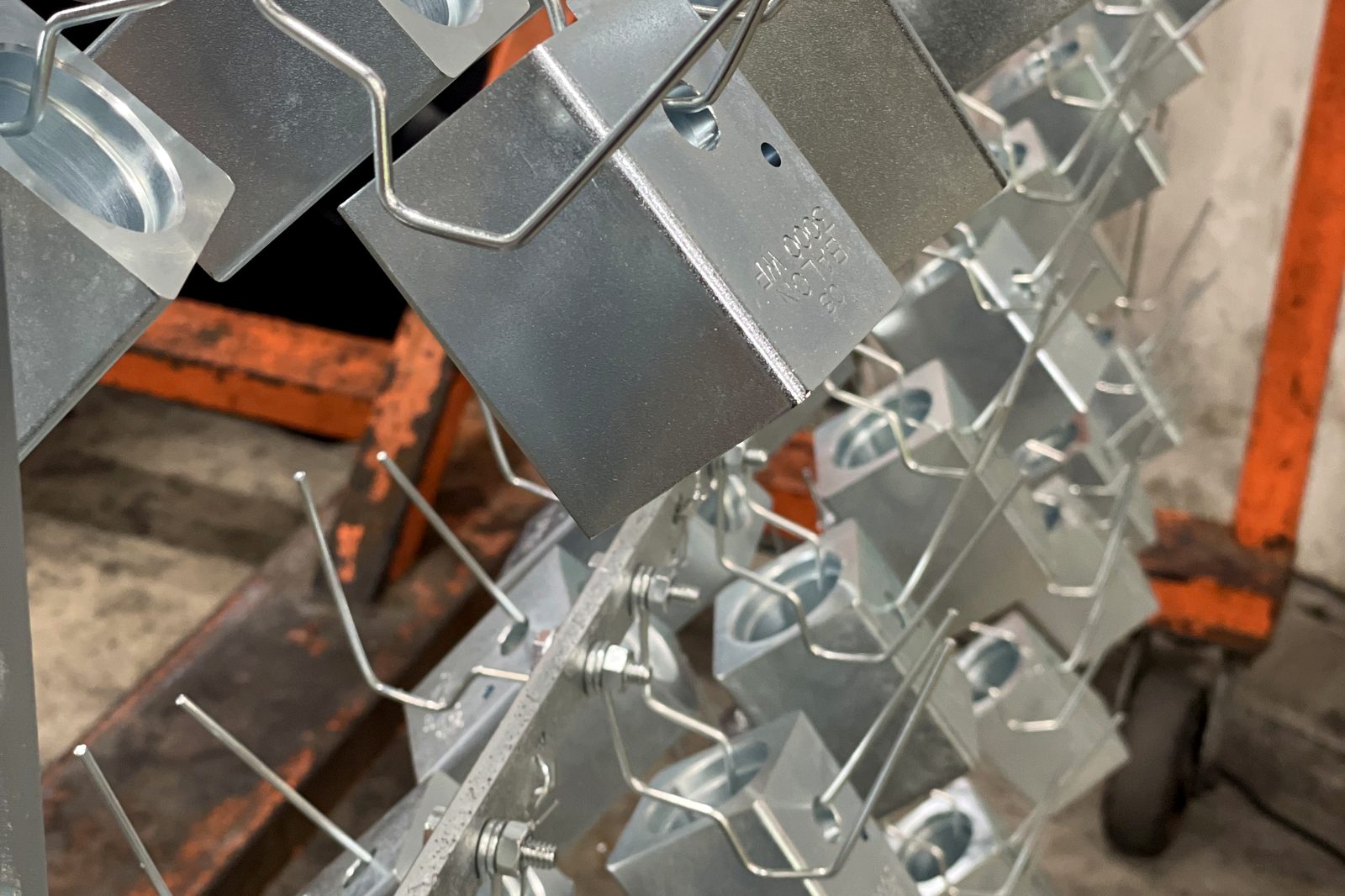 Racked steel parts finished in clear alkaline zinc
