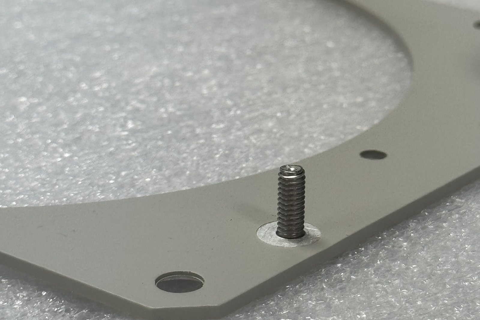 Finished coated part with a masked stud, packed on protective foam